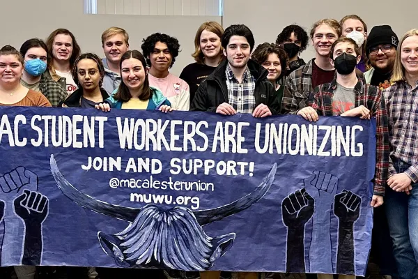 student workers hold the muwu uaw banner